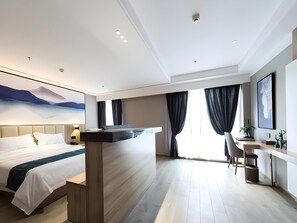 Una habitación de hotel moderna con cama, escritorio y un amplio ventanal con cortinas.