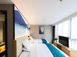 A hotel room with a bed, a TV, and a large window.
