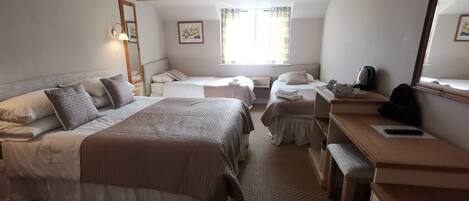 Habitación de hotel con dos camas, un escritorio, una silla, un espejo y una ventana.