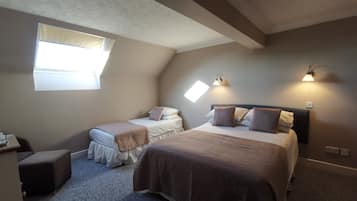 Un dormitorio con dos camas, una ventana e iluminación en la pared.