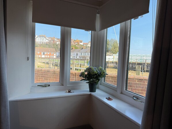 A corner window with a view of residential buildings and a fenced area. - River Haven Hotel (Rye)