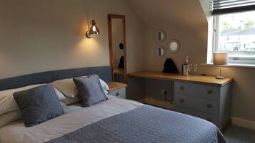 A bedroom with a bed, a dresser, a mirror, and a window with blinds.