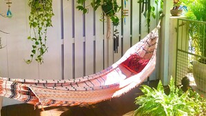 A hammock suspended between white slats, with hanging plants and a chandelier. - One minute's walk to Freights Bay (Freights Bay)