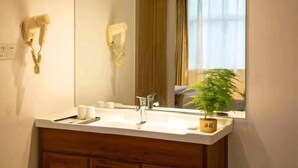 A bathroom with a white sink, a mirror, and a towel rack. - Greentree Inn Henan Shangqiu Yongcheng Ouya Road Business Hotel (Shangqiu)