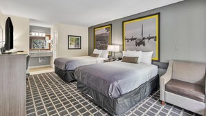 A hotel room with two beds, a desk, a chair, a bathroom, and artwork on the walls. - Super 8 by Wyndham Morganton (Morganton)