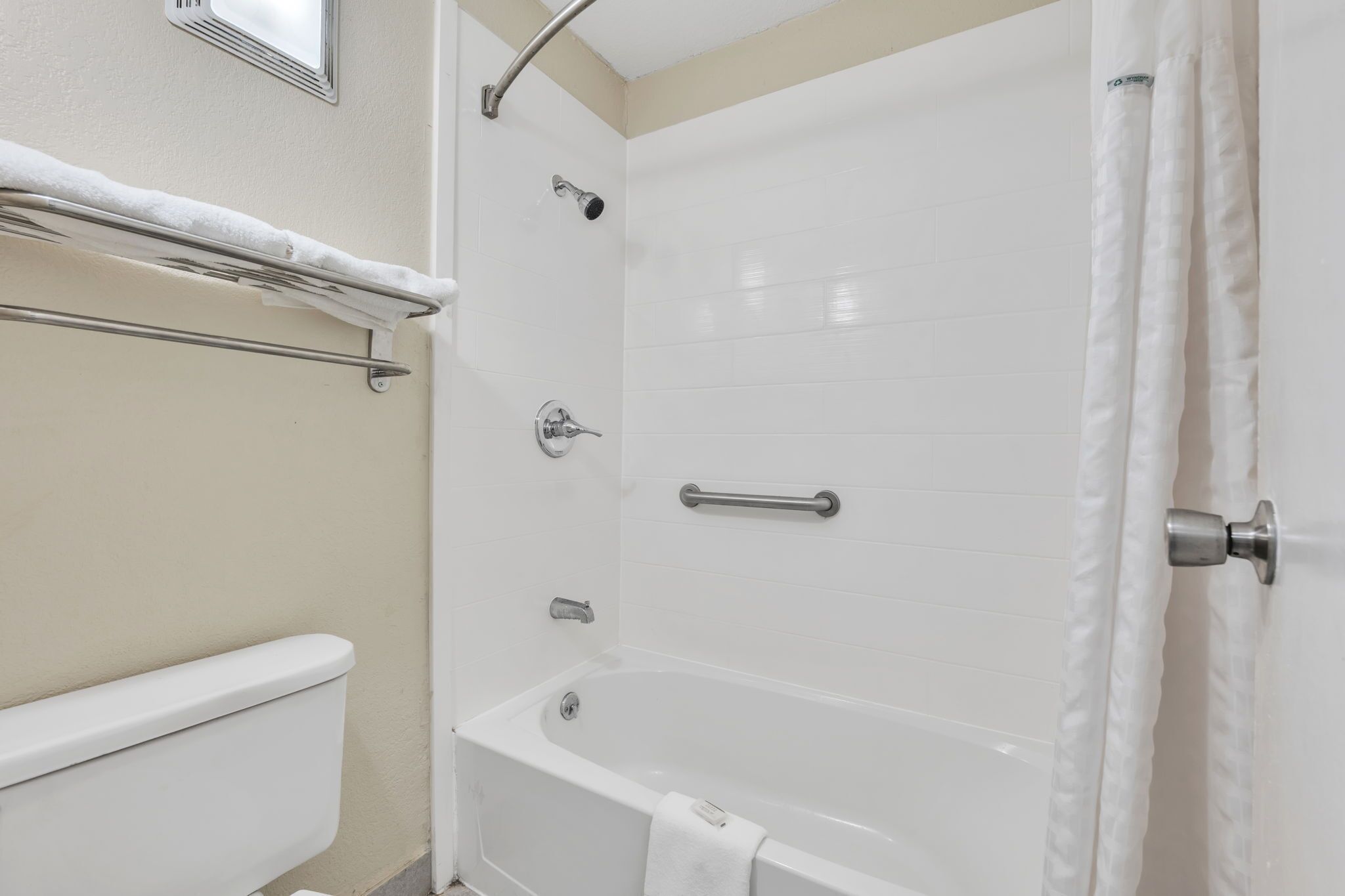 A bathroom with a bathtub, a toilet, and a shower.