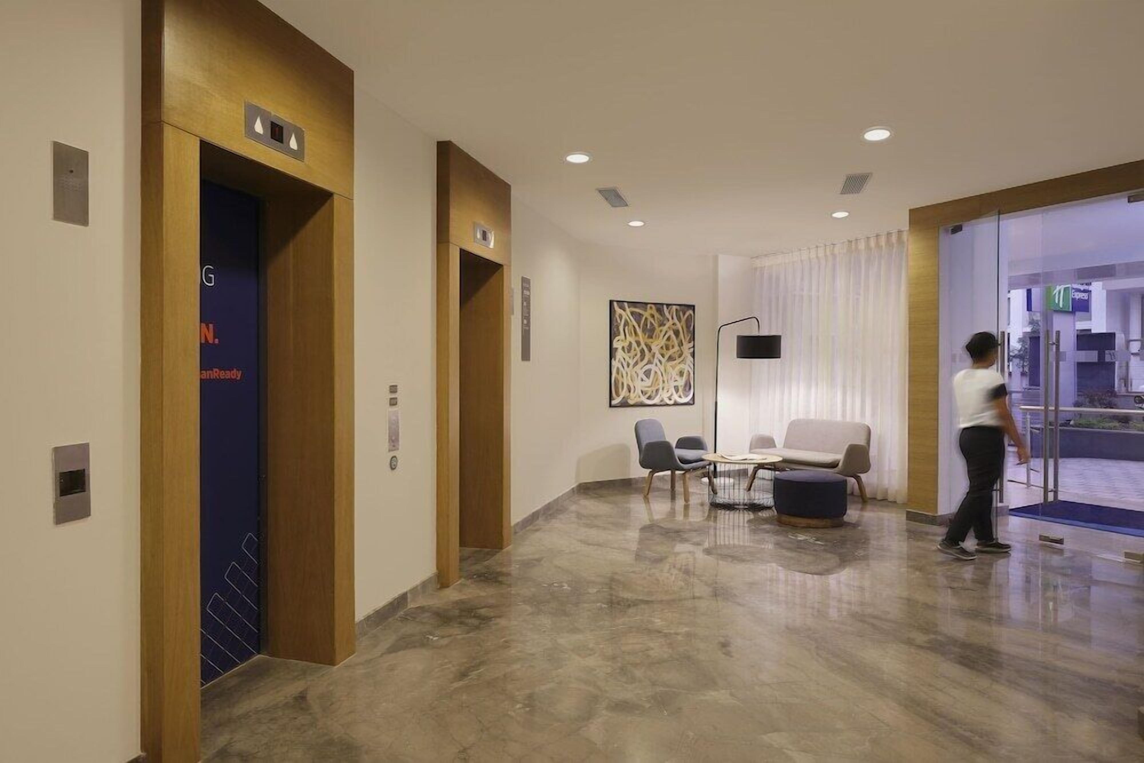A modern lobby with a marble floor, a reception desk, and a seating area.
