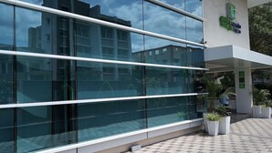 A modern building with large glass windows and a tiled walkway. - Holiday Inn Express Pune Pimpri (Pune)