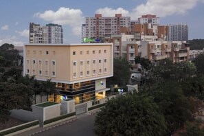 A multi-story hotel with a flat facade, a central entrance, and a parking area. - Holiday Inn Express Pune Pimpri (Pune)