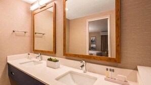 A modern bathroom with two sinks, a large mirror, and a wooden-framed mirror. - Aiden By Best Western Cape Cod - West Yarmouth (West Yarmouth)
