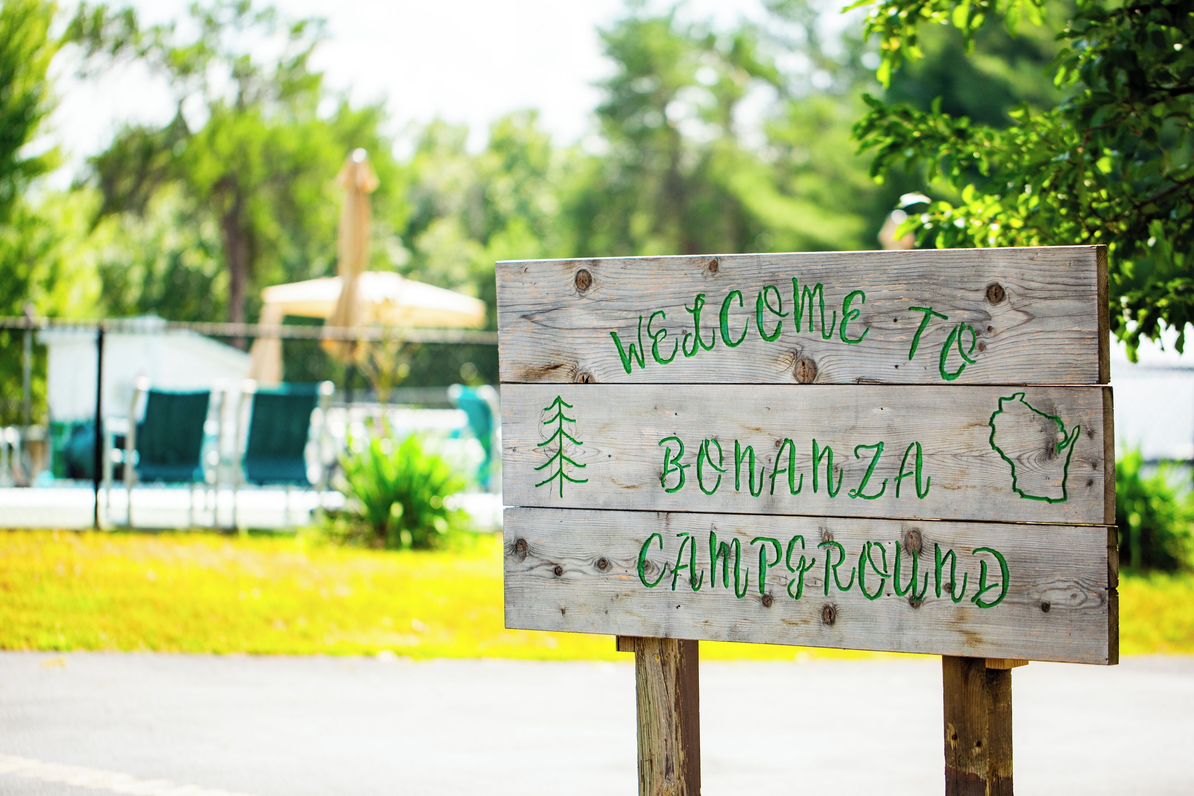 Uma placa de madeira com a inscrição 'WELCOME TO BONANZA CAMPGROUND'.