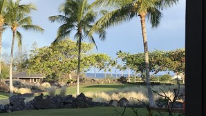A view of a golf course with palm trees and a body of water in the background. - Secluded 2-Suite - Stocked Like you're at home. Ocean front pool, private lanai (Waikoloa Village)