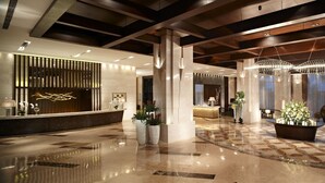 A spacious lobby with a polished marble floor, a reception desk, and a large, modern chandelier. - Mission Hills Resort Haikou (Haikou)