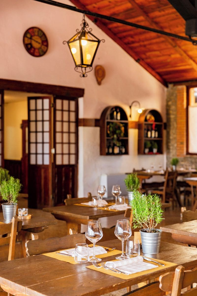 Ein Restaurant mit Holztischen und -stühlen, Topfpflanzen und einer traditionellen japanischen Einrichtung.