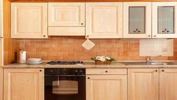 Una cucina con mobili in legno, un piano cottura, una lavastoviglie e un lavandino.