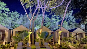 A pool area with lounge chairs and a swimming pool, surrounded by trees and small buildings. - Zensus Eco Boutique Hotel (Bacalar)