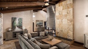 A modern living room with a sectional sofa, a coffee table, and a fireplace.