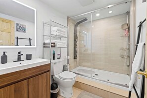 A modern bathroom with a glass-enclosed shower, a white toilet, a vanity with a mirror, and a shelf with towels. - Cozy, quiet and private retreat at Cottage Spa & Lake Villa Sinaia, amazing view (Chertsey)