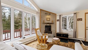A cozy room with large windows, a fireplace, a wooden chair, and a bed. - Cozy, quiet and private retreat at Cottage Spa & Lake Villa Sinaia, amazing view (Chertsey)