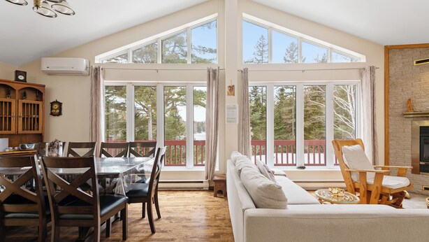 A spacious living area with a high ceiling, large windows, a fireplace, and a dining area with wooden furniture. - Cozy, quiet and private retreat at Cottage Spa & Lake Villa Sinaia, amazing view (Chertsey)
