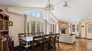 A spacious living area with a dining table, wooden chairs, a sofa, and a fireplace. - Cozy, quiet and private retreat at Cottage Spa & Lake Villa Sinaia, amazing view (Chertsey)
