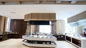 A modern kitchen with a central island, built-in cabinets, and a large window providing natural light. - Dongsheng · Yuyuan Hotel (Qixia)