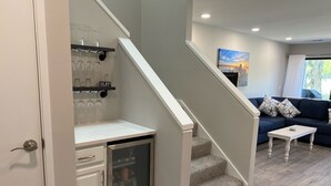 A compact kitchen with a built-in refrigerator, a small countertop, and a wine rack.