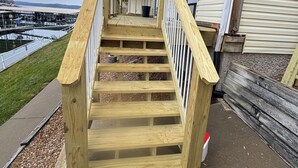 Eine Holztreppe führt zu einer Veranda mit Blick auf eine Marina.