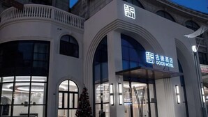 Un edificio moderno con un cartello che indica “Good Hotel” e un albero di Natale all'esterno.