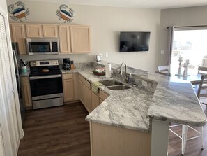 Enjoy cooking in this well-equipped kitchen with a microwave, stainless steel range, and coffee maker.