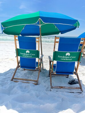 Relax in comfort with two beach chairs and umbrellas on the sandy beach.