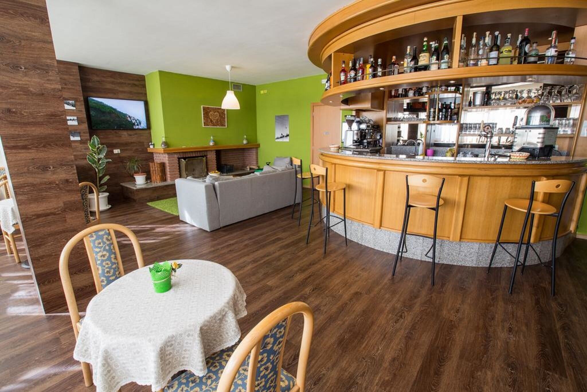A modern living area with a bar, a fireplace, and a dining table with chairs.