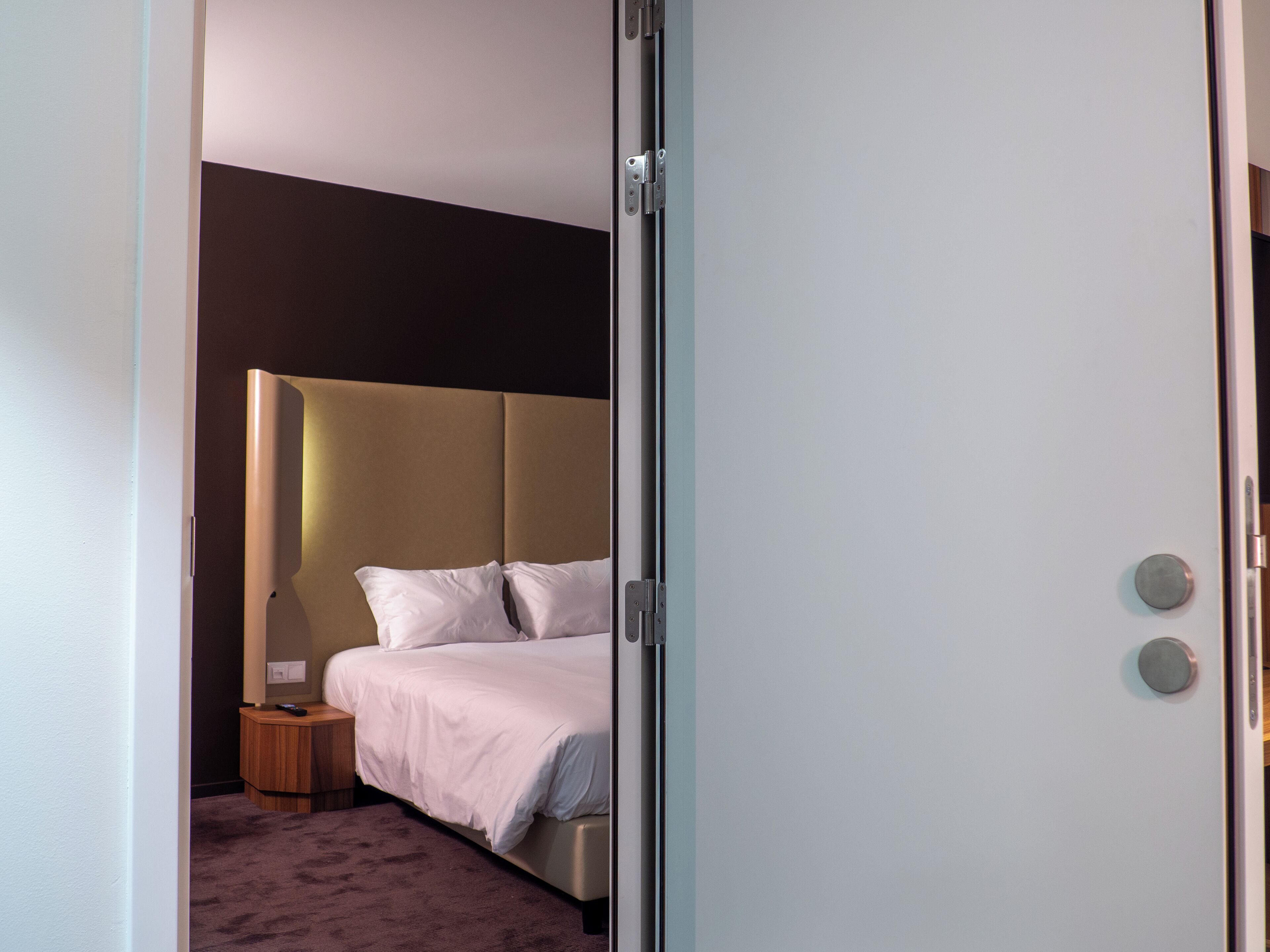 Un dormitorio con cama, mesita de noche y velador.