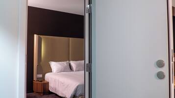 Un dormitorio con cama, mesita de noche y velador.