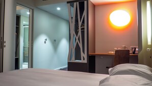 A hotel room with a bed, a desk, and a bathroom visible through an open door. - Flag Hotel Caldas da Rainha (Caldas da Rainha)