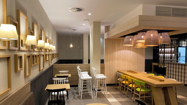 A modern restaurant with wooden furniture, pendant lighting, and a checkered floor. - Flag Hotel Caldas da Rainha (Caldas da Rainha)
