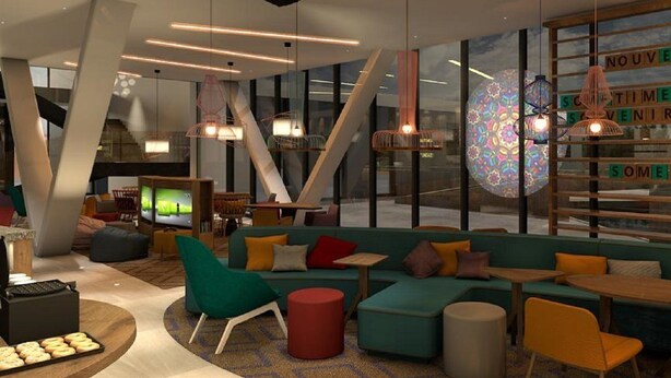 A modern lounge area with a large window, comfortable seating, and a television. - Hampton by Hilton Alcobendas (Alcobendas)