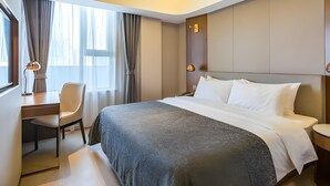 Una habitación de hotel moderna con una cama grande, un escritorio y una silla.