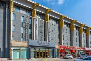 Un hotel con fachada moderna, amplias ventanas y una entrada destacada.