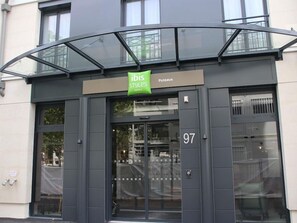 A hotel entrance with a glass canopy, a sign for 'ibis Styles Hotels,' and the number '97' on the door. - Ibis Styles Puteaux Paris La Defense (Puteaux)