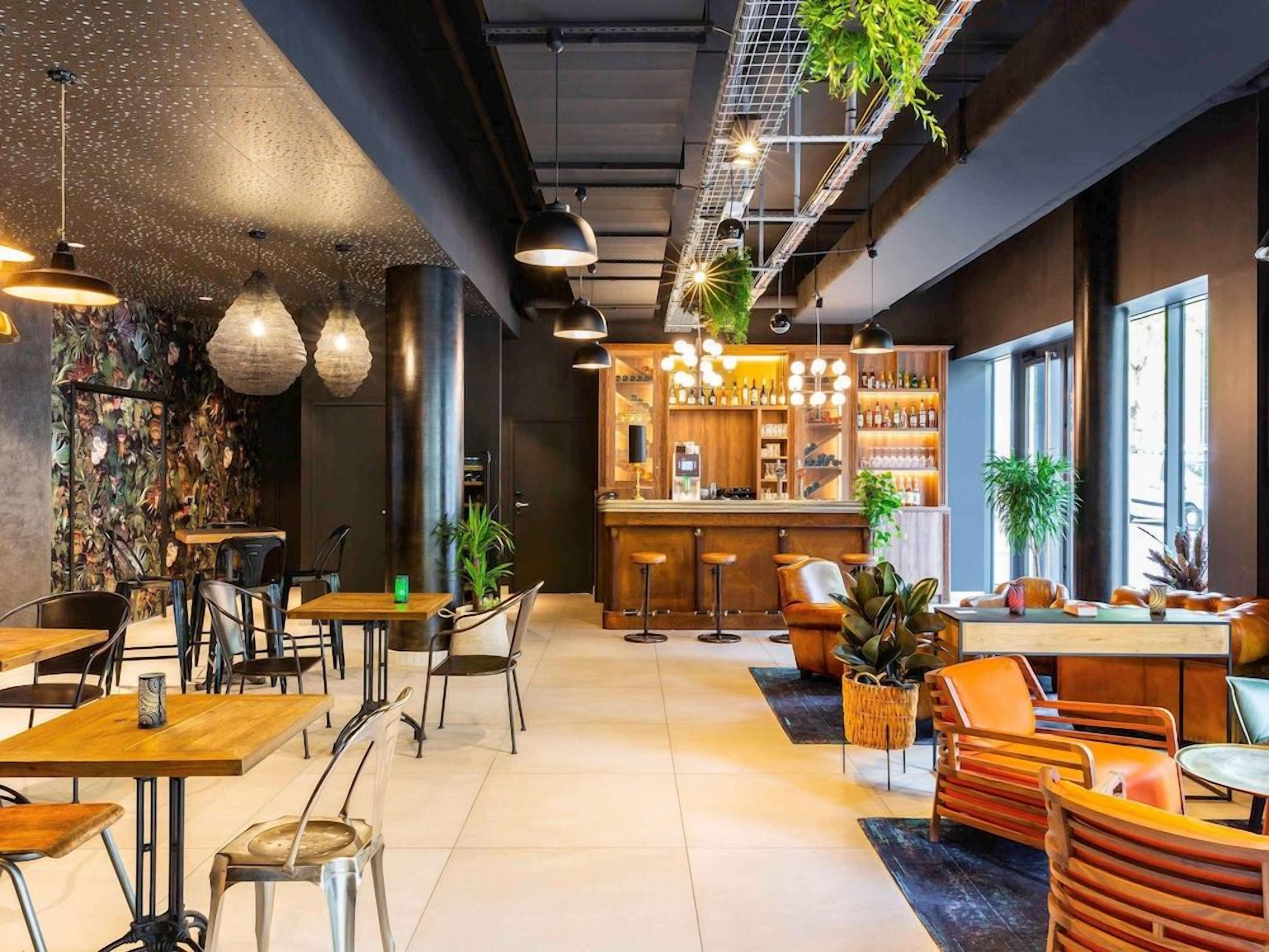 Un espace bar moderne, doté de sièges et d’un comptoir.