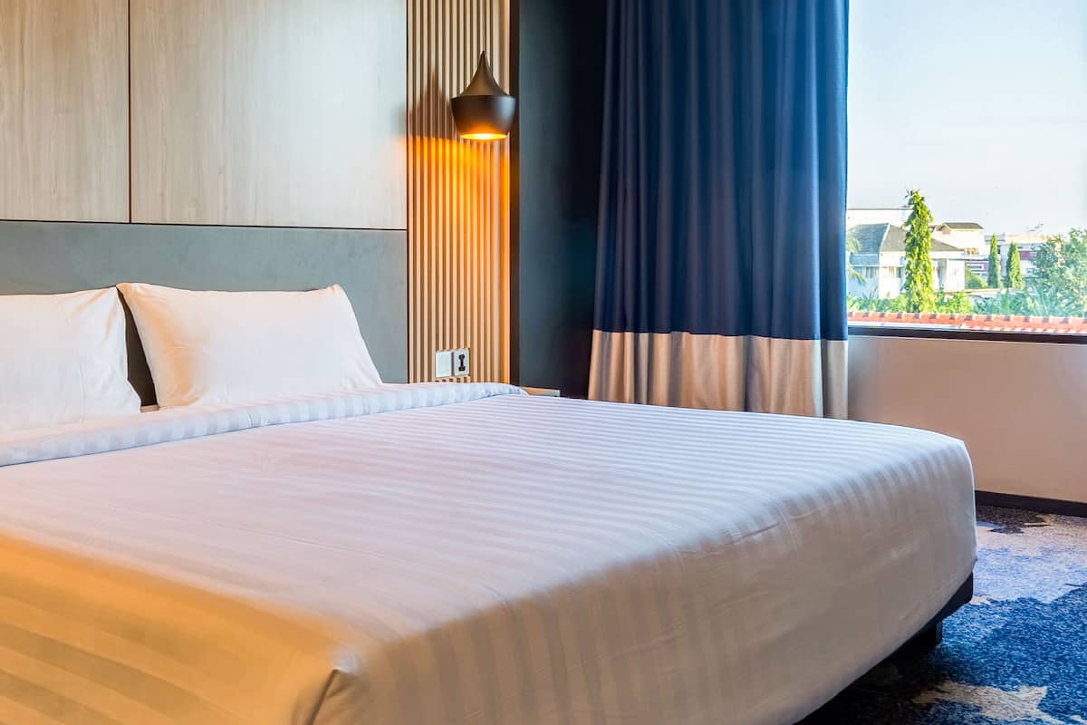 Une chambre d’hôtel dotée d’un grand lit, offrant une vue sur l’extérieur et présentant un design moderne.