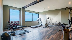 Une salle de sport équipée de tapis de course, de vélos elliptiques et de poids libres.