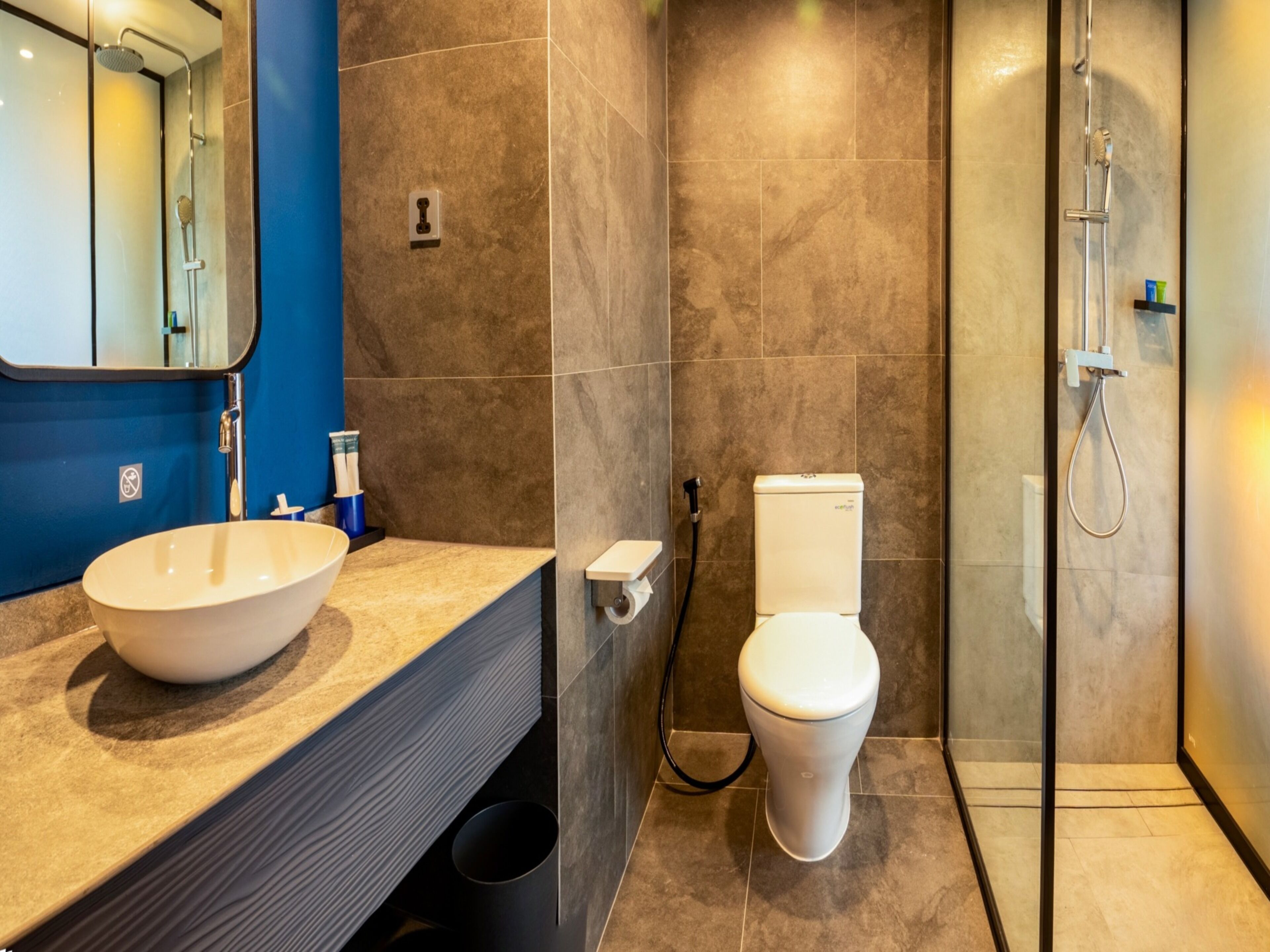 A modern bathroom with a large sink, toilet, and shower.