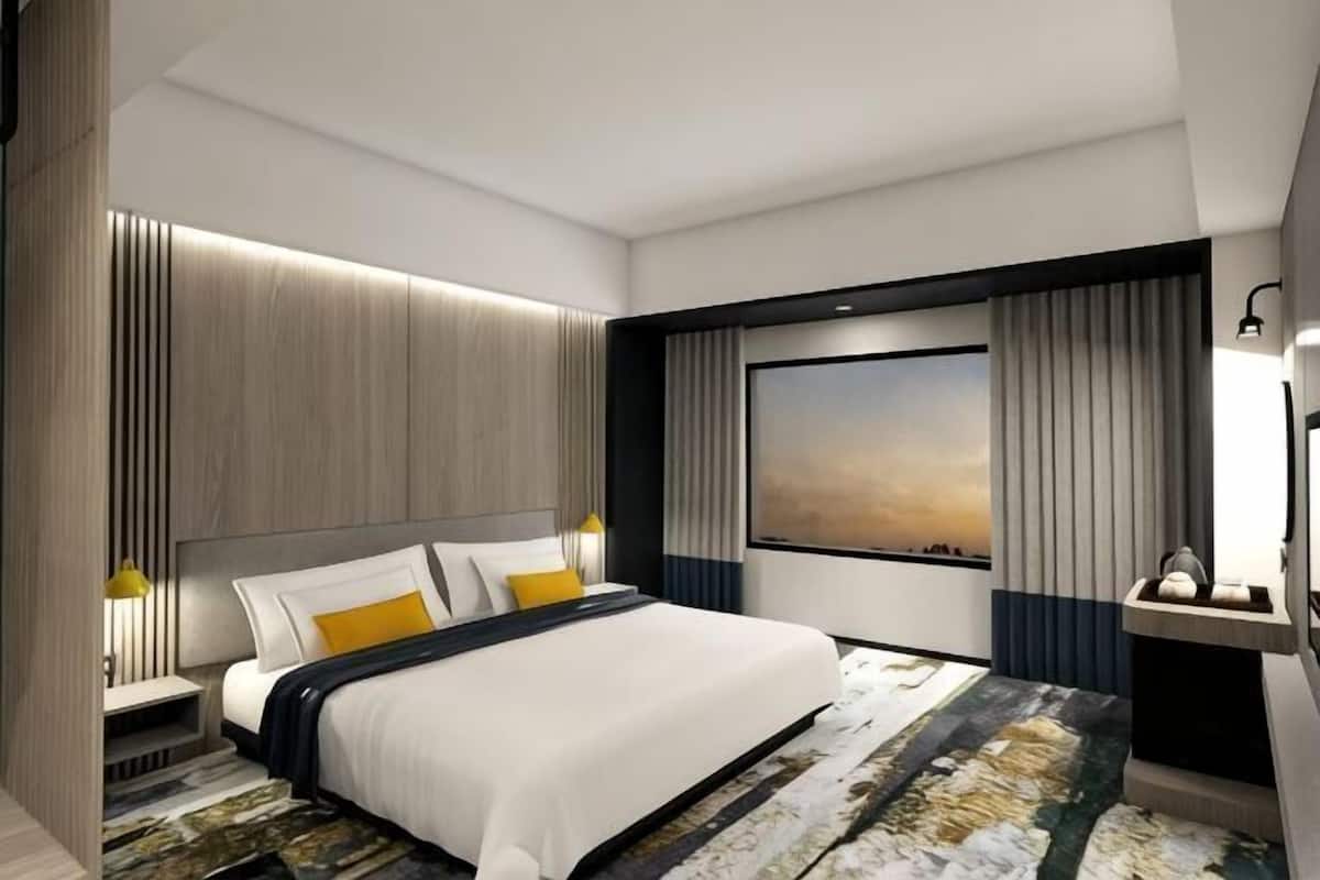 Une chambre d’hôtel moderne avec un grand lit, une vue sur le paysage urbain et un mur décoratif en bois.