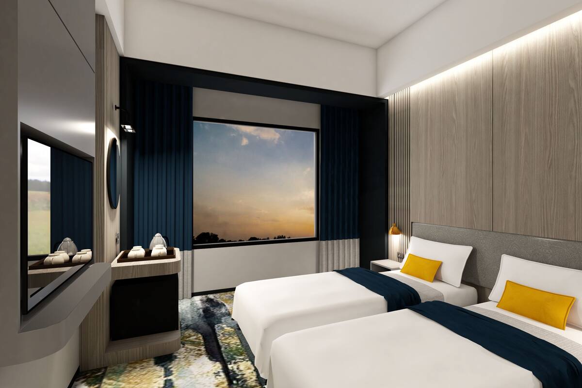 Une chambre d’hôtel moderne avec deux lits, une grande fenêtre et une vue sur le ciel.