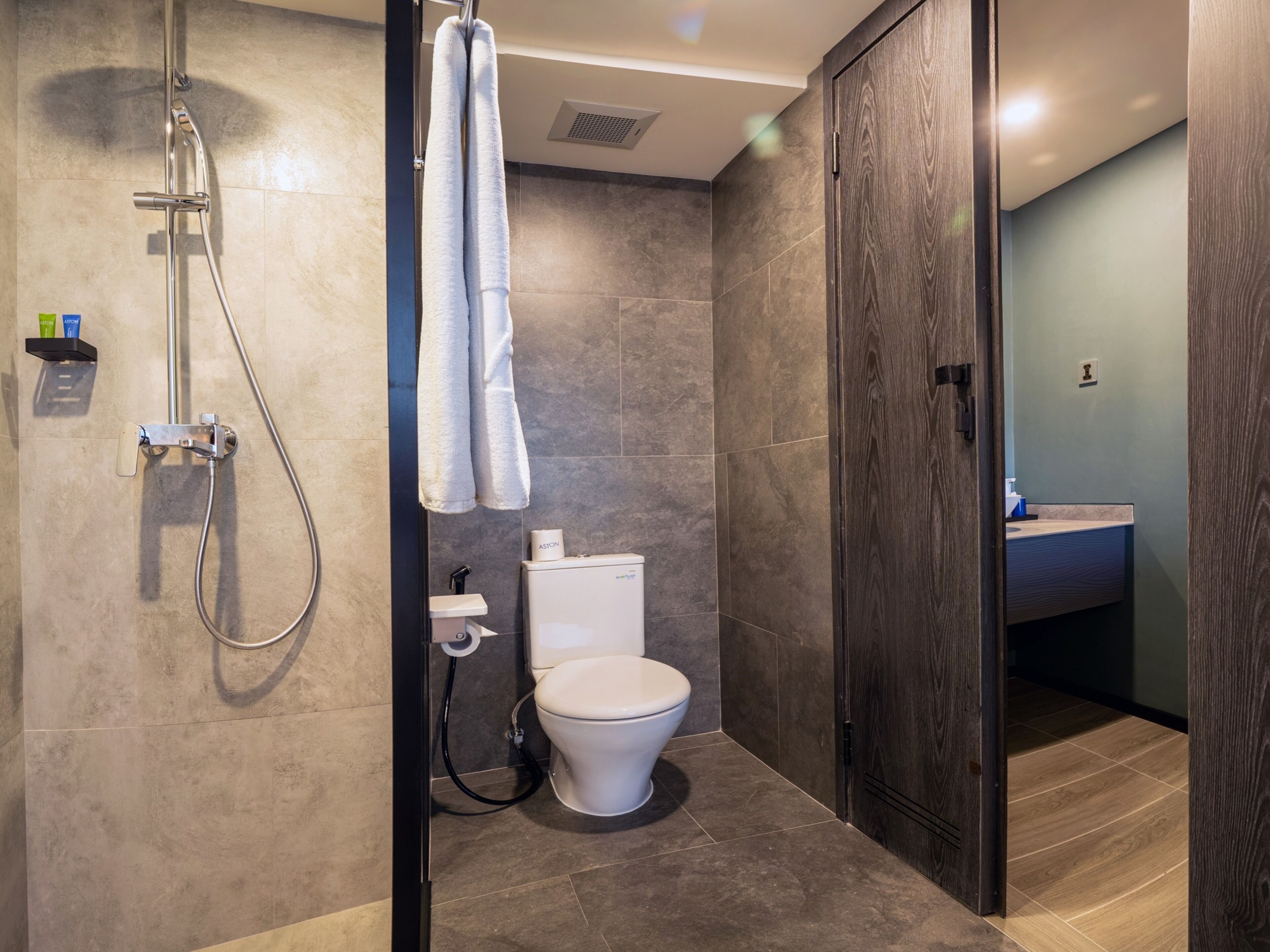 Un baño moderno con ducha, inodoro y lavamanos.