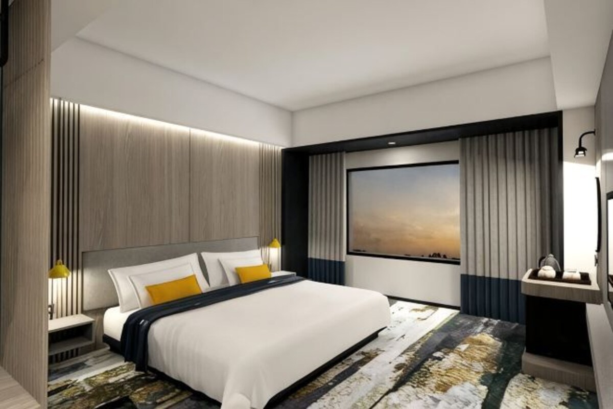 Una habitación de hotel moderna con una cama grande, vistas a la ciudad y una pared decorativa de madera.