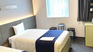 A hotel room with a bed, a small round table, a chair, a desk, and a window with curtains. - Hotel Monday Premium Ueno Okachimachi (Tokyo)