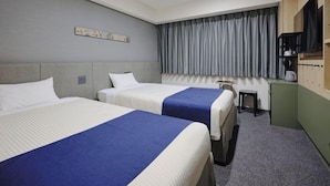 A hotel room with two beds, a small desk, a television, and a window with curtains. - Hotel Monday Premium Ueno Okachimachi (Tokyo)